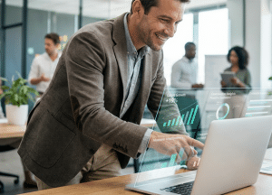 Businessman in busy modern office standing over desk looking at laptop with floating UI screens
